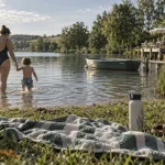 Parc de loisirs du lac de l'uby : enfant dans l’eau peu profonde, serviette et ombre